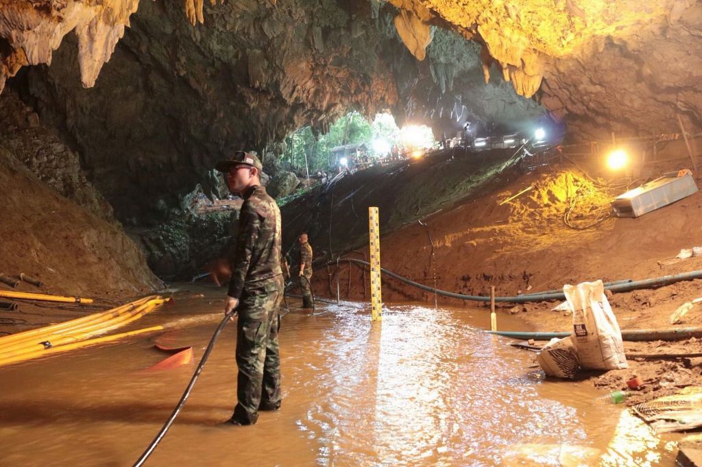 Thai rescue teams arrange water pumping system at the entrance to a flooded cave complex where 12 boys and their soccer coach have been trapped since June 23 in Mae Sai Chiang Rai provin