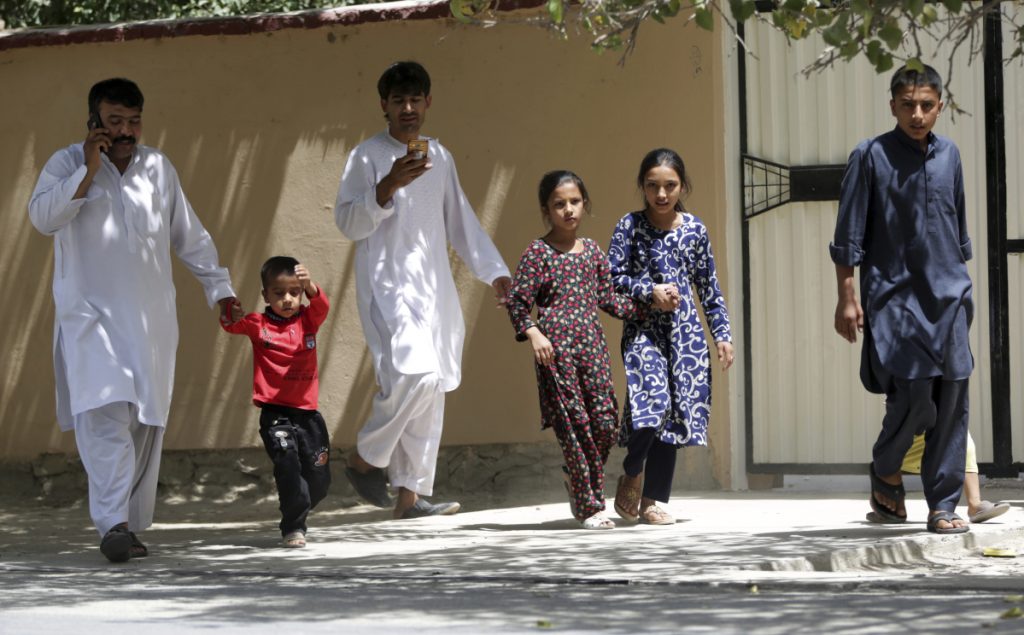 Families leave their homes Thursday in Kabul where two gunmen engaged police in a six-hourlong standoff at an Afghan intelligence service compound before the security forces killed them. The violence followed Wednesday's killing of 34 youths