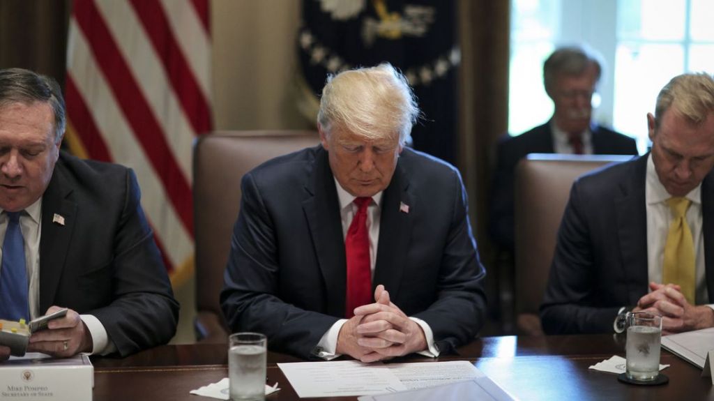 President Donald Trump prays during a cabinet meeting were they discussed sanctions