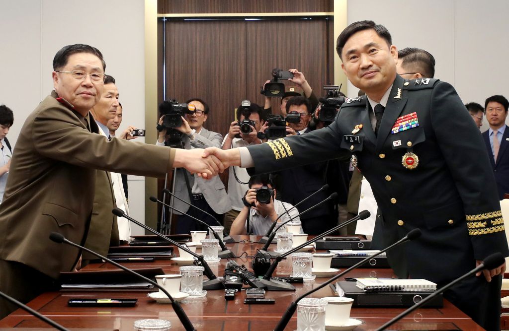 General An Ik San of North Korea left shakes hands with Major General Kim Do-gyun of South Korea during a meeting at the border village of Panmunjom