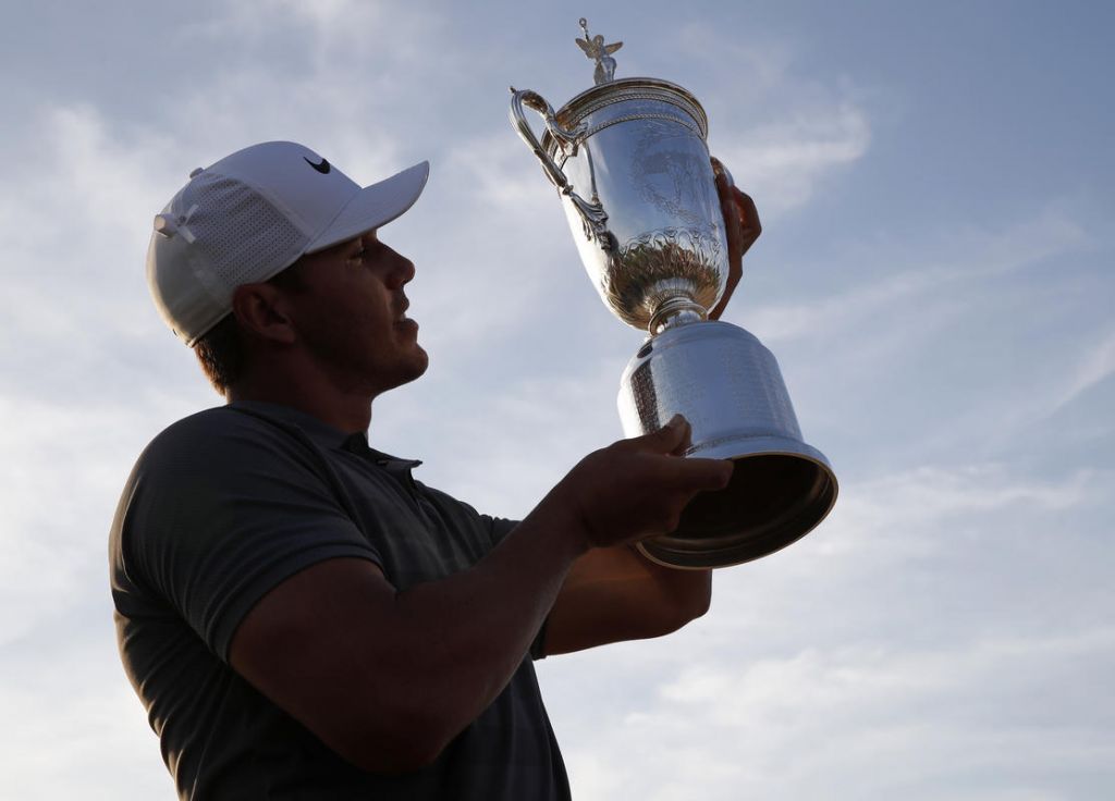 Brooks Koepka holds up the Golf Champion Trophy after winning the U.S. Open Golf Championship Sunday