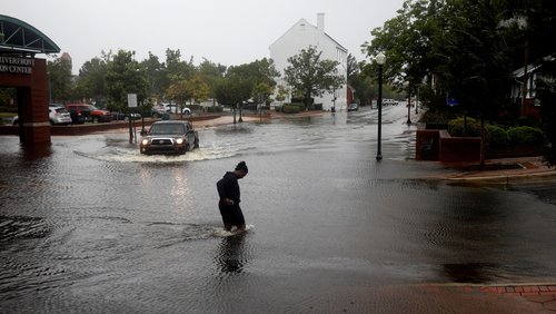 A man crosses a flooded street in New Bern North Carolina