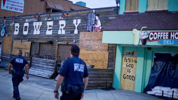 Police patrol past boarded up shops along the boardwalk in Myrtle Beach South Carolina ahead of Hurricane Florence's