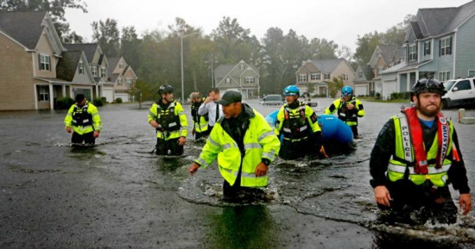 The Latest: Flooded city sets curfew; roads unpassable