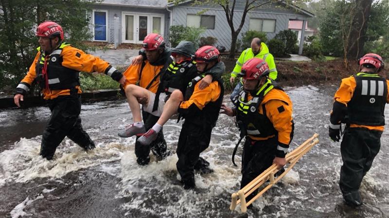 Rescue workers carry a man to safety in River Bend New York