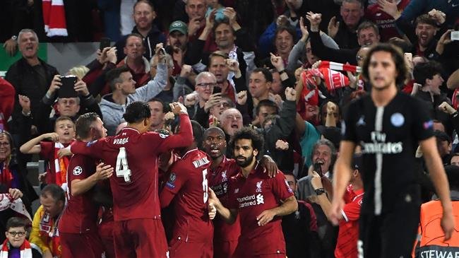 Liverpool's English midfielder James Milner celebrates with teammates after scoring a penalty during the UEFA Champions League group C football match between Liverpool and Paris Saint Germain at Anfield in Liverpool north west England on September 18