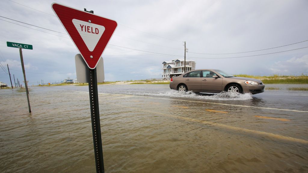 A car drives through a road as it slowly begins to flood as Tropical Storm Gordon approaches on Tuesday Sept. 4 2018 in Dauphin Island Ala. Boaters are evacuating to safe harbors and motorists are fleeing barrier islands as the Gulf Coast hustles