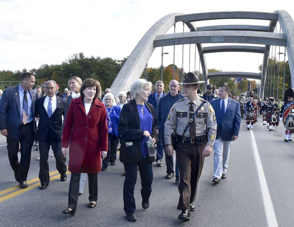 Sheryl Cole center walks with Sen. Susan Collins and her son Somerset County Sheriff's Deputy David Cole as they and hundreds of others cross the newly dedicated Cpl. Eugene Cole Memorial Bridge named in honor of her husband in Norridgewock