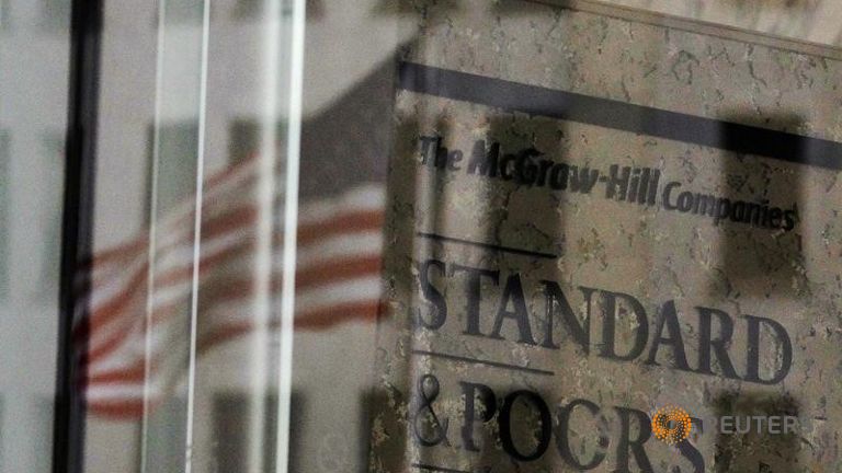 A U.S. flag is reflected in a window of the Standard and Poor's building in New York