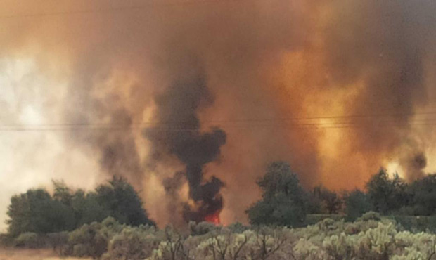 A quickly-spreading near I-90 threatened homes Monday afternoon