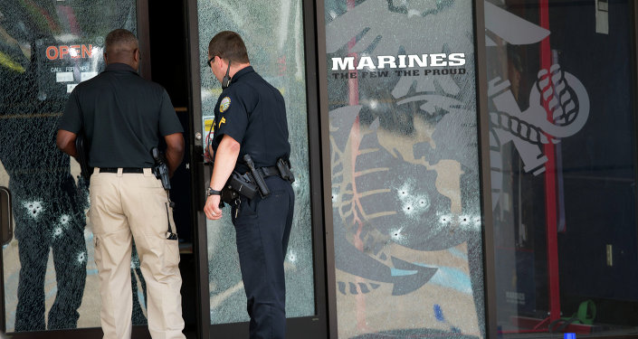 Police officers enter the Armed Forces Career Center through a bullet-riddled door after a gunman opened fire on the building Thursday