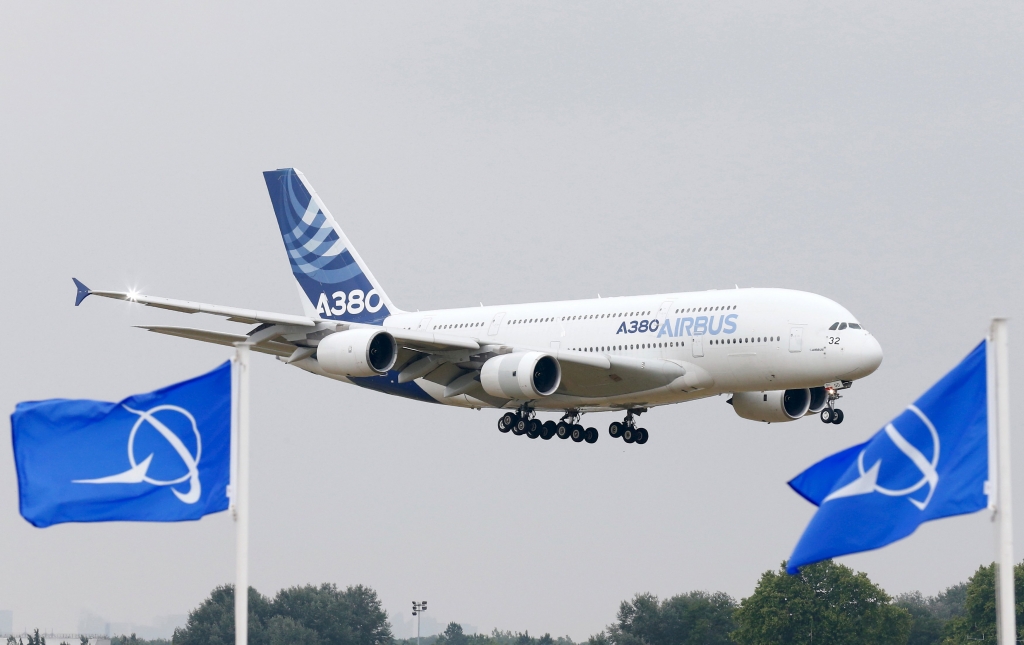 An Airbus A380 the world's largest jetliner flies over Boeing flags as it lands after a flying display during the 51st Paris Air Show at Le Bourget airport near Paris