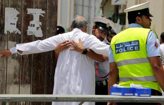 Bahraini community police officers search worshipers outside a Shiite Muslim mosque ahead of mid-day prayers in Manama. Bahraini authorities say two policemen have been killed and many injured in a bomb attac