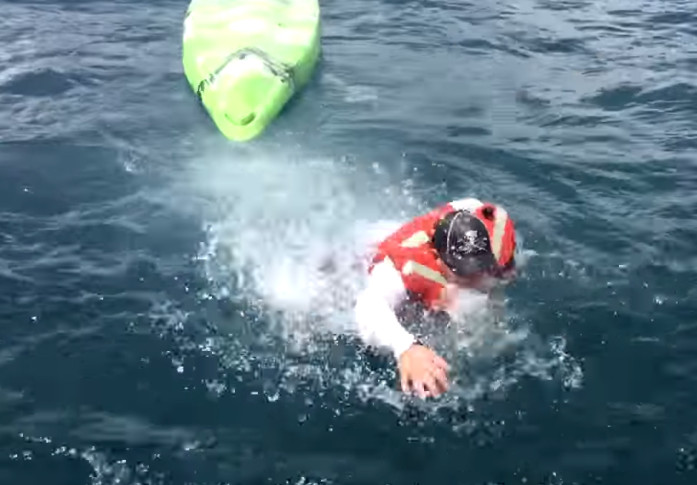 Ben Chancey swims to a support boat after a shark capsized his kayak