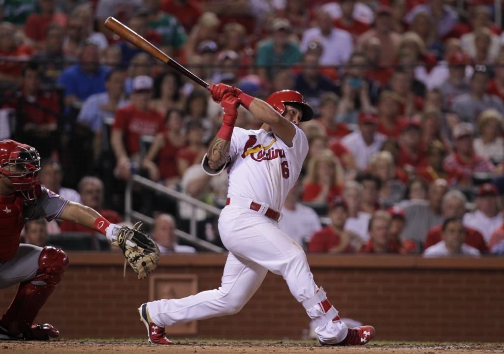 St. Louis Cardinals Kolten Wong swings hitting a grand slam home run in the fourth inning against the Cincinnati Reds at Busch Stadium in St. Louis