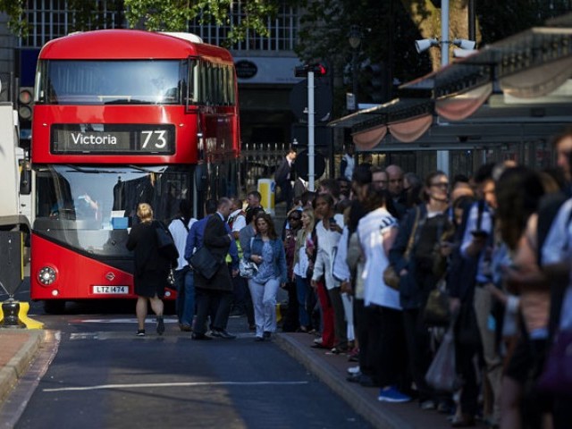 Early morning commuters form queues to board buses at Victoria station during a tube strike in London