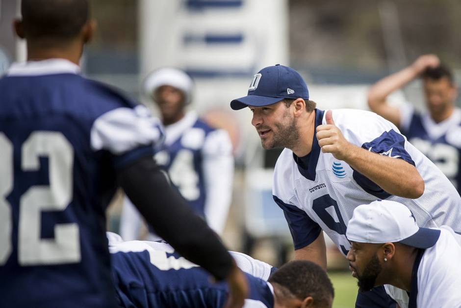 Dallas Cowboys quarterback Tony Romo gives a thumbs up to his teammates during the morning walkthrough on the first day of the team training camp on Thursday