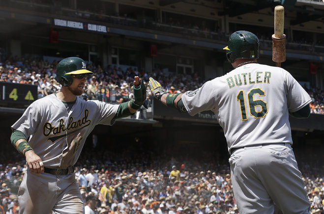 Oakland Athletics Ben Zobrist left is congratulated by Billy Butler after scoring against the San Francisco Giants during the fourth inning of a baseball game in San Francisco Sunday