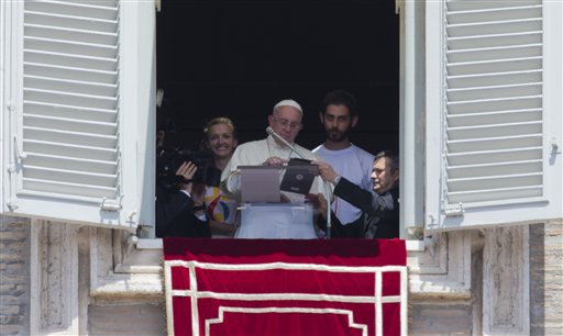 Pope Francis uses a tablet computer to sign himself up for next year’s World Youth Day in Poland during the Angelus noon prayer he celebrated from the window of his studio overlooking St. Peter's Square at the Vatican Sunday