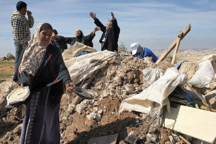 Palestinians try to retrieve items from the rubble of a house after it was destroyed by IDF tractors near the West Bank village of Susya in 2011