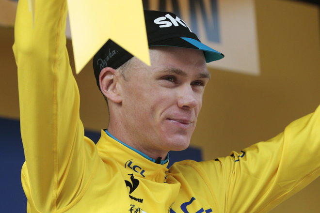 Britain's Christopher Froome wearing the overall leader's yellow jersey celebrates in on the podium of the ninth stage of the Tour de France cycling race a team time-trial over 28 kilometers with start in Vannes and finish in Plumelec Fra