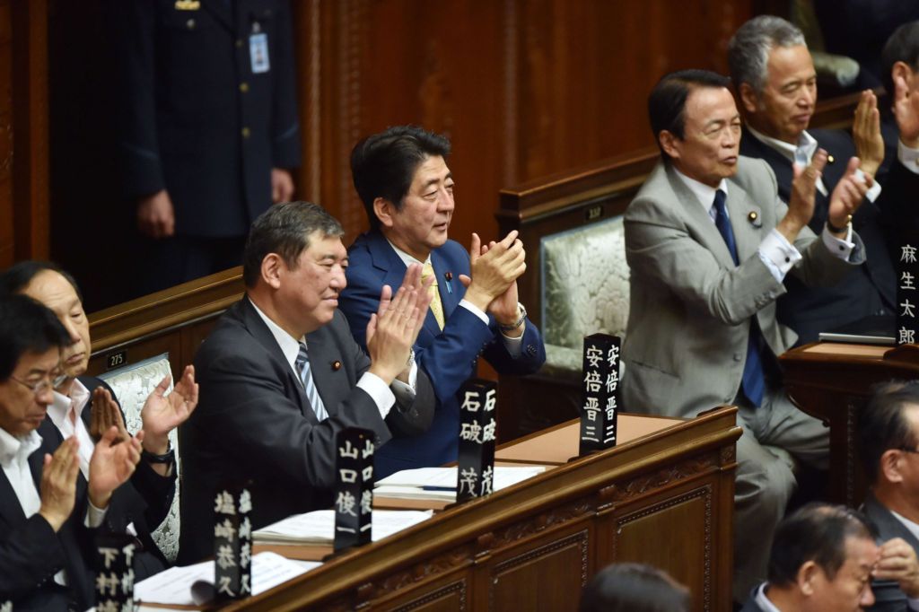 Prime Minister Shinzo Abe and LDP allies in Japan's lower house of parliament applaud after the passing of two bills allowing Japanese troops to be deployed abroad