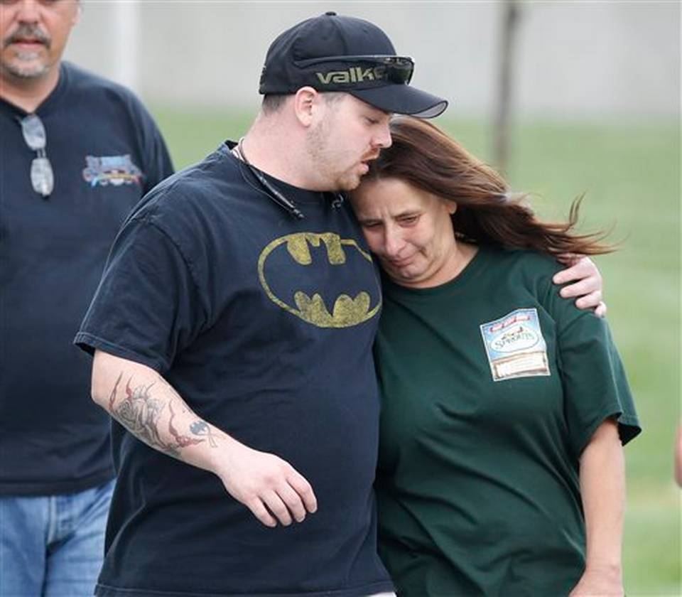 An unidentified man in a T-shirt bearing a Batman emblem hugs a woman as they emerge from the Arapahoe County Courthouse after jurors convicted James Holmes in the July 2012 massacre at a movie theater as the trial concluded Thursday