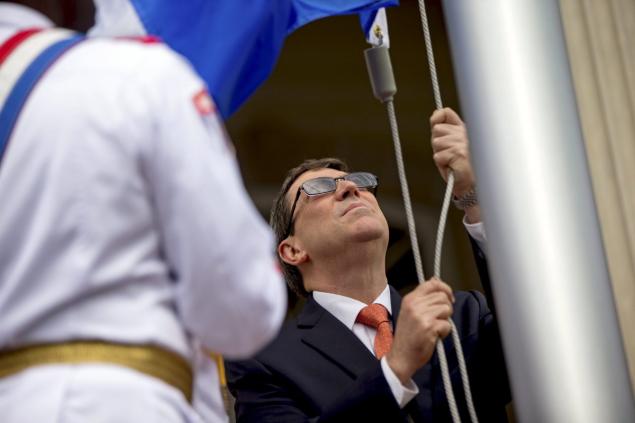 Cuban Foreign Minister Bruno Rodriguez raises the Cuban national flag over their new embassy in Washington July 20