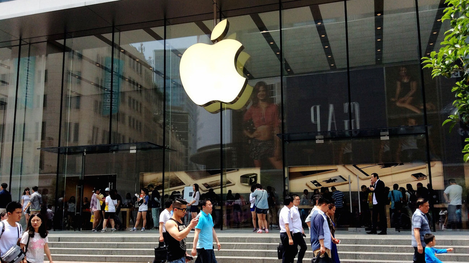 Pedestrians walk past a store of Apple in Shanghai China