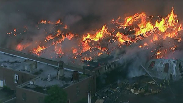 Police say a warehouse in New Jersey that is 50 football fields big and full of cars caught fire Wednesday morning