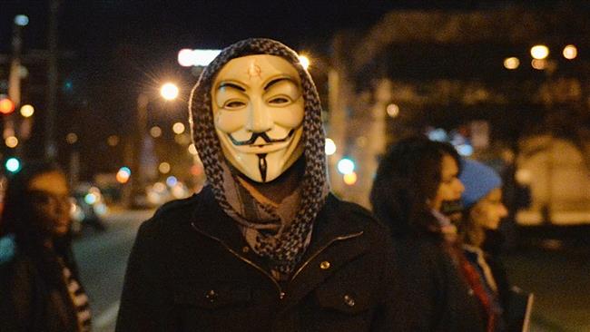 A protester wearing a mask associated with a group of hacker activists known as Anonymous