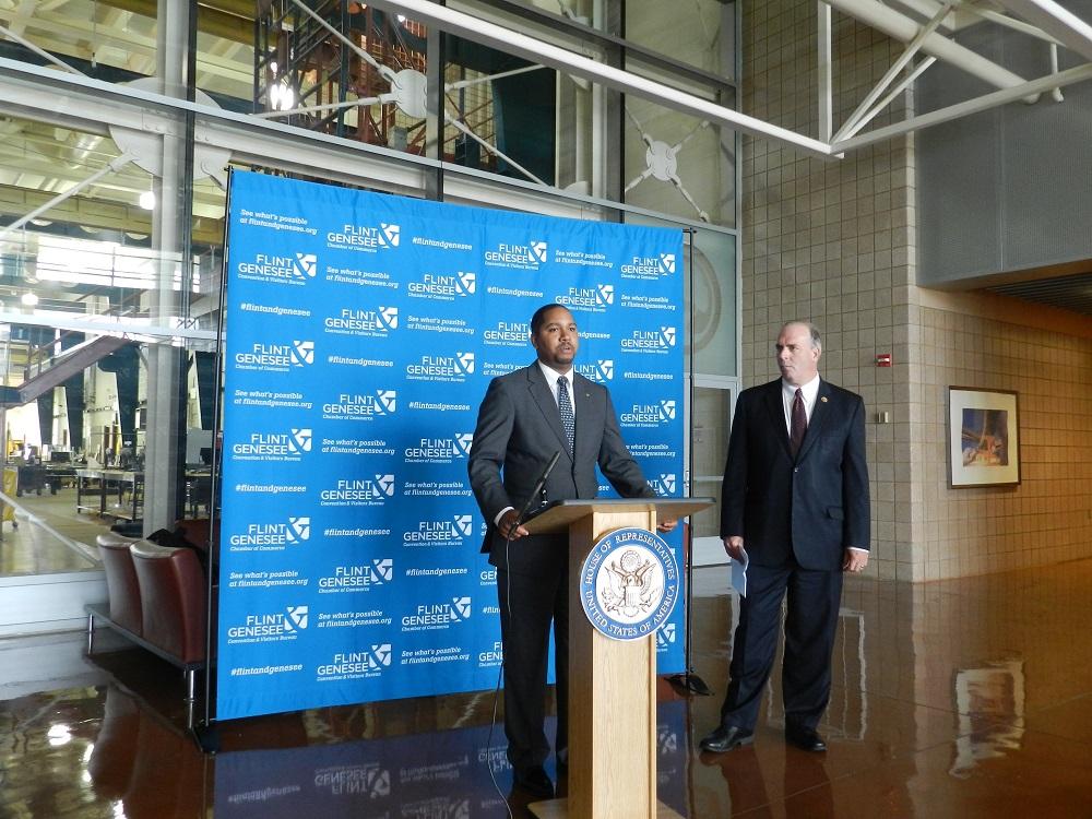 Kyle Mc Cree with the Flint Genessee County Chamber of Commerce talks to the news media before a recent business round table on the Export Import Bank. Rep. Dan Kildee listens