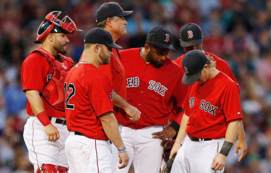 Boston Red Sox manager John Farrell third from left looks to the bullpen as players from left Sandy Leon Mike Napoli Pablo Sandoval Xander Bogaerts partially hidden and Brock Holt wait for a relief pitcher after Clay Buchholz left the baseball