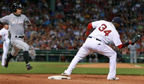 David Ortiz stretches to take the throw from pitcher Robbie Ross Jr. to force out Ichiro Suzuki in the top of the seventh inning Wednesday