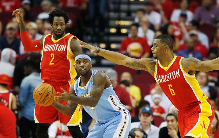 Ty Lawson #3 of the Denver Nuggets looks to pass between Patrick Beverley and Terrence Jones #6 of the Houston Rockets during their game at the Toyota Center