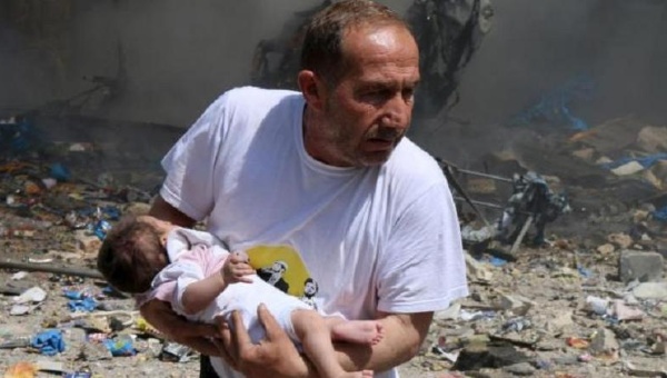 A man holds a baby that survived what activists said was a site hit by a barrel bomb dropped by forces loyal to Syrian President Bashar al Assad at the old city of Aleppo