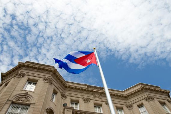 The Cuban flag is raised over their new embassy in Washington Monday