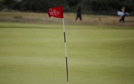 The flag at the 15th hole waves in the strong winds which saw play suspended on the third day at the British Open