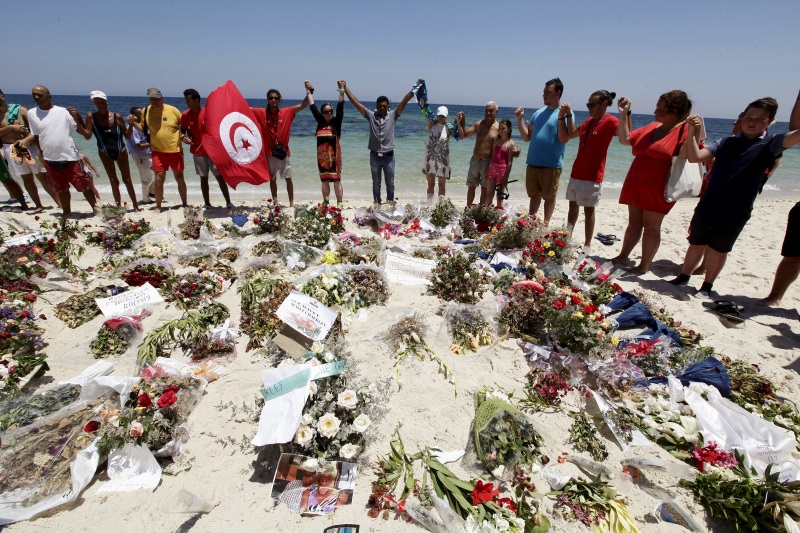 People join hands as they observe a minute's silence in memory of those killed in a recent attack by an Islamist gunman at a beach in Sousse Tunisia