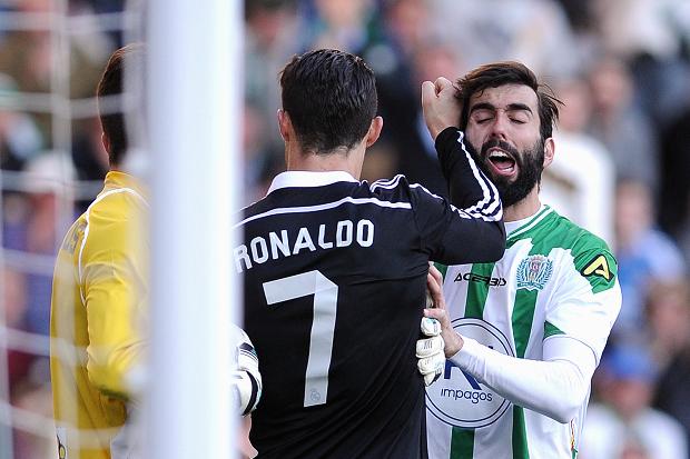 Cristiano Ronaldo left strikes Cordoba’s defender Jose Angel Crespo