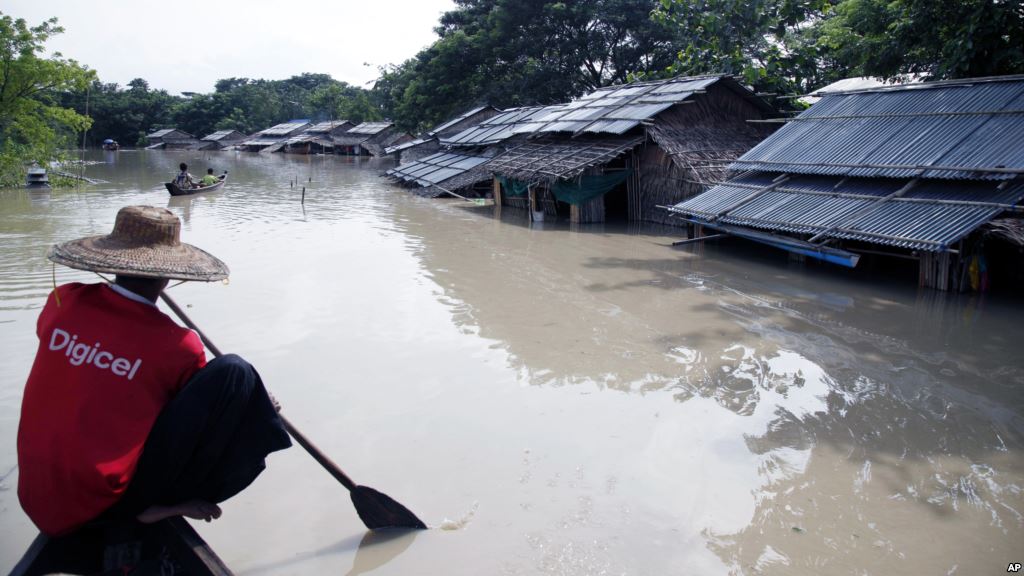 A man paddles his boat near flooded homes in Nyaung Tone Irrawaddy delta about 100 kilometers southwest of Yangon Myanmar Aug 5 2015