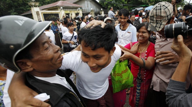 A released prisoner centre is welcomed by his family outside Insein Prison in Yangon on Thursday