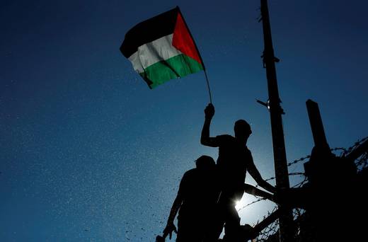 A spectator waves a Palestinian flag