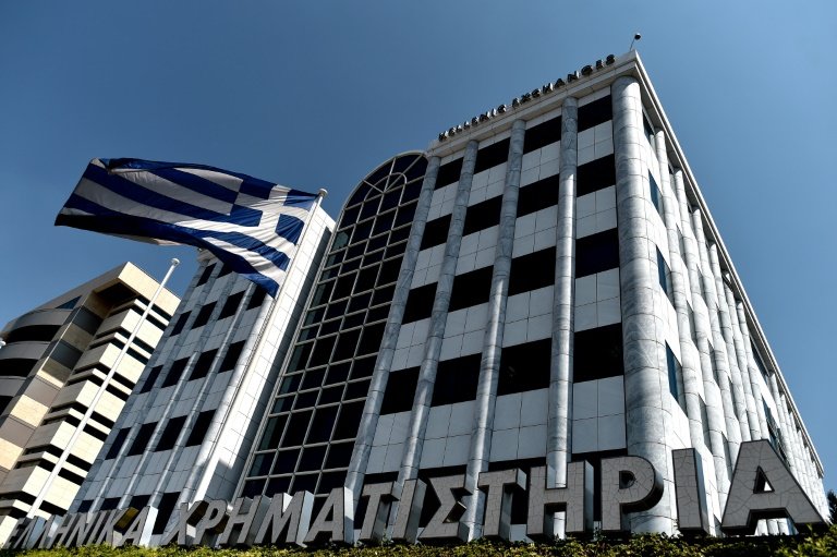 A Greek flag waves outside the Athens Stock Exchange