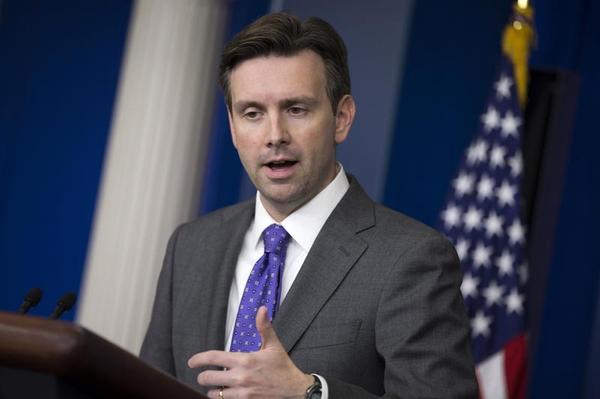 White House press secretary Josh Earnest gestures as he answers a question during the daily press briefing at the White House in Washington Wednesday Oct. 8 2014. Earnest talked about temperature screenings at five airports for passengers arriving from