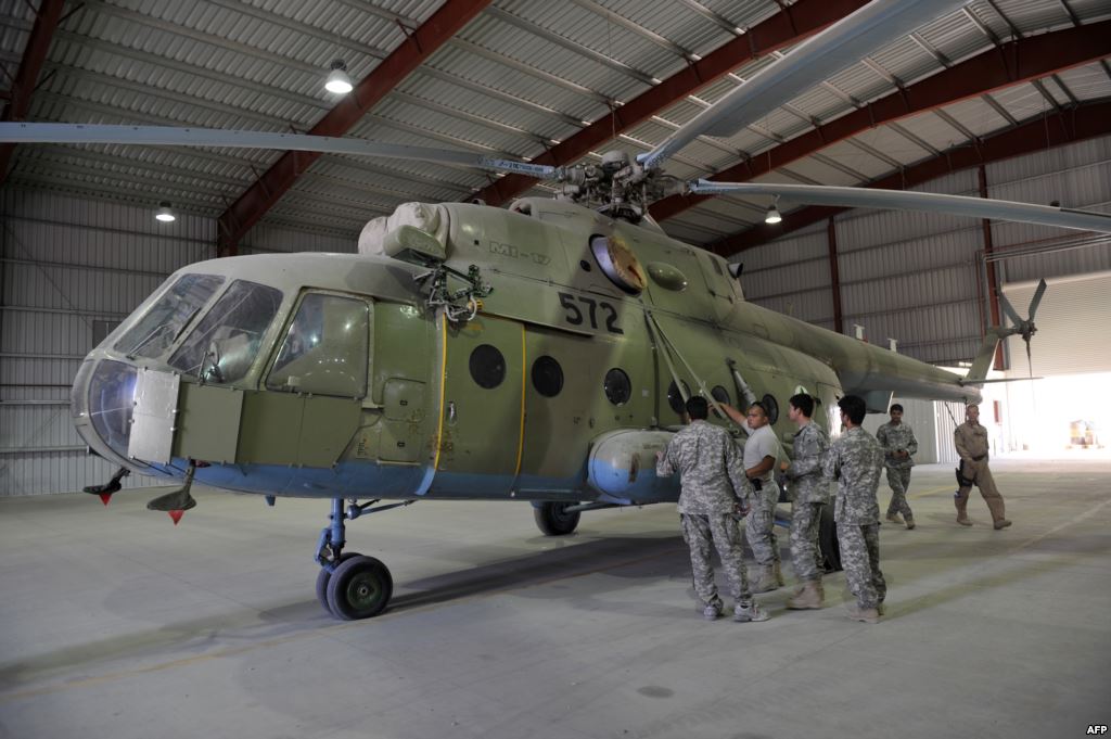 A U.S. Air Force soldier gives explanations to a group of Afghan translators for the Afghan National Army Air Corps on the Russian Mi-17 transport helicopter at a hangar in Kandahar air base in October 2009