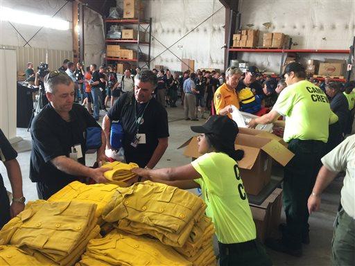 Warren Heslip 47 of Southland New Zealand receives a yellow firefighting shirt on Monday Aug. 24 2015 at the National Interagency Fire Center in Boise Idaho. Australian and New Zealand firefighters have arrived in the United States and prepared