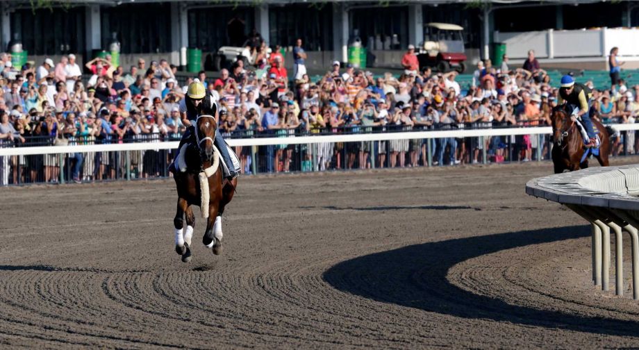 In front of a large crowd of fans Top Clearance left with Calamity Compton up leads Triple Crown winner American Pharoah with Jorge Alvarez up through at Monmouth Park in Oceanport N.J. Saturday Aug. 1 2015 a turn as they train for Sunday's runnin