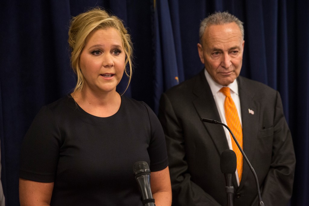 Amy Schumer smiles at her distant cousin Senator Chuck Schumer during a news conference in New York Monday Aug. 3 2015. They are teaming up to try to enact gun control regulations