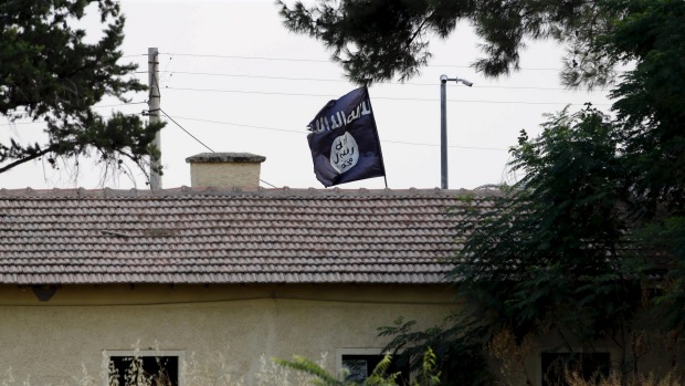 An Islamic State flag flies over the custom office of Syria's Jarablus border gate